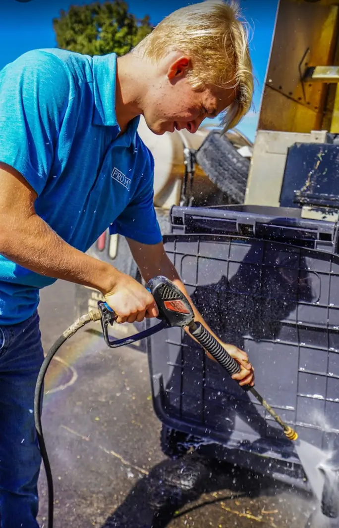 Pro-MTC team member cleaning trash cans while building leadership skills
